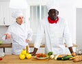 Cook and chef having quarrel in kitchen Royalty Free Stock Photo