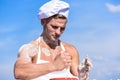 Cook or chef with muscular shoulders and chest mixing flour in bowl. Cookery concept. Man on confident face wears Royalty Free Stock Photo