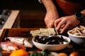 Cook chopping celery on cutting board surrounded by a variety of ingredients.