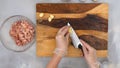 Cook chopping garlic on wooden chopping board. Sour cream chicken paprika recipe