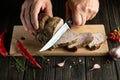 The cook cuts the baked veal meat before preparing dinner. The concept of cooking. Dark background for advertising or recipe Royalty Free Stock Photo