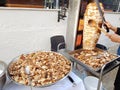 A cook cuts chicken meat on a skewer to cook shawarma