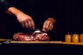 The cook cuts the fat on the neck, prepares the meat for marinating and roasting Royalty Free Stock Photo