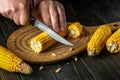 Cook cuts the grains of corn with a knife. Maize is an excellent dietary breakfast or lunch by the hands of the chef