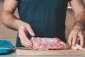 The cook cuts the pork ribs into pieces for cooking Royalty Free Stock Photo