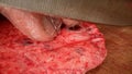 The cook cuts raw meat with a knife. male hands cut meat for steak on a wooden board. The turn cuts the meat with a Royalty Free Stock Photo