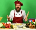Cook with excited face in burgundy uniform holds rolling pin Royalty Free Stock Photo