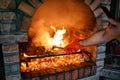 Cook flips the ribs with tongs on the fire in the oven. Cropped Royalty Free Stock Photo