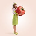 Cook girl holding a large tomato