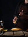 The cook is grating cheese. There is a pile of grated cheese on a black plate. On the left in the photo are eggs, sauce. Color Royalty Free Stock Photo