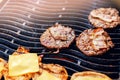 Cook grills burger patties and cheese pork ribs open fire. Turns meat over with tongs Royalty Free Stock Photo