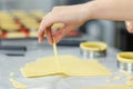 The cook hand raises a strip of dough