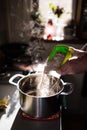 Cook hands adding rye flour to a kettle