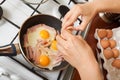 Cook hands adds eggs to hot skillet