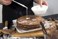 Cook hands apply cream on cake Royalty Free Stock Photo