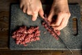Cook hands cut red meat on the board. nearby are tomatoes, onion, butter Royalty Free Stock Photo