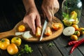 The cook hands cuts a tomato on a kitchen cutting board. Peasant food for preparing preserves in a jar Royalty Free Stock Photo