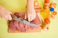 Cook hands cutting beef