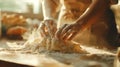 Cook hands kneading dough, sprinkling piece of dough with white wheat flour