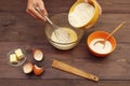 Cook hands pouring flour into a bowl for making dough on wooden table Royalty Free Stock Photo