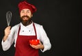 Cook with happy face in burgundy uniform holds bowl, whisk Royalty Free Stock Photo