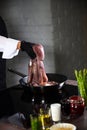 Cook holds the octopus over the pan. Cooking an octopus dish. Seafood dishes. Protein food. An unrecognizable person. Vertical