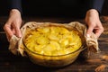 Cook holds potato casserole with his hands