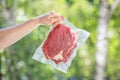 The cook holds the vacuum-packed meat