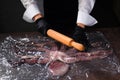 Cook holds a wooden rolling pin and cuts a fresh whole octopus. Octopus in plastic wrap. Seafood dishes. Protein food. An