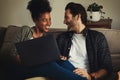 Cook lets order in. a happy young couple using a laptop while relaxing on a couch in their living room at home. Royalty Free Stock Photo