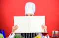 Cook looking for cooking recipe in cookbook. Woman reading cook book in kitchen. Girl cook at kitchen table ingredients Royalty Free Stock Photo