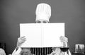 Cook looking for cooking recipe in cookbook. Woman reading cook book in kitchen. Girl cook at kitchen table ingredients Royalty Free Stock Photo