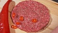 Cook makes meat medallions for burgers. Chef in black food gloves makes cutlet. Cutlets are leveled in steel ring in an