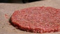 Cook makes meat medallions for burgers. Chef in black food gloves makes cutlet. Cutlets are leveled in steel ring in an