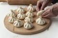 Cook making khinkali, dumplings, meat in the dough cooking with hands.