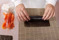 Cook making sushi rolls with salmon