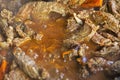 cook meat cut into pieces in a frying pan with vegetables, top view. Royalty Free Stock Photo