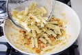 The cook mixes the pasta with a thick sauce and vegetables Royalty Free Stock Photo