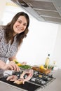 Cook - plus size woman grill fish in kitchen Royalty Free Stock Photo