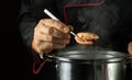 The cook in the pot prepares shrimps. The chef checks the readiness of the shrimp. Kitchen tool in the chef hand