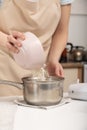 Cook pours flour into the dough. Process of cooking. Mixing ingredients