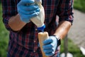 The cook pours the sauce, mayonnaise into a bun roll for hot dog