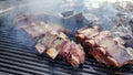 A Cook prepares Barbecues a lot of big Grilled Ribs on the fire with Beef Meat Lamb and Pork marinated in a sauce for a Royalty Free Stock Photo