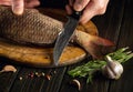 The cook prepares raw fresh fish with spices. Preparation for cutting fish with a knife in the hand of the chef. Working Royalty Free Stock Photo