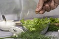 the cook prepares the salad and salts it with salt