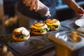 Cook preparing burger adding the sauce on the cream cheese. Royalty Free Stock Photo