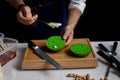 Cook preparing burger adding the sauce on green bun. Royalty Free Stock Photo