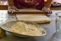 Cook preparing a daugh with a wooden rolling pin