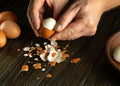 The cook is preparing a delicious breakfast with boiled eggs on the kitchen table. Peeling eggs from the shell with the hands of a Royalty Free Stock Photo