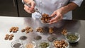 Cook preparing diabeticfriendly snacks with precise portioning of nuts and seeds on a stainless steel counter background Royalty Free Stock Photo